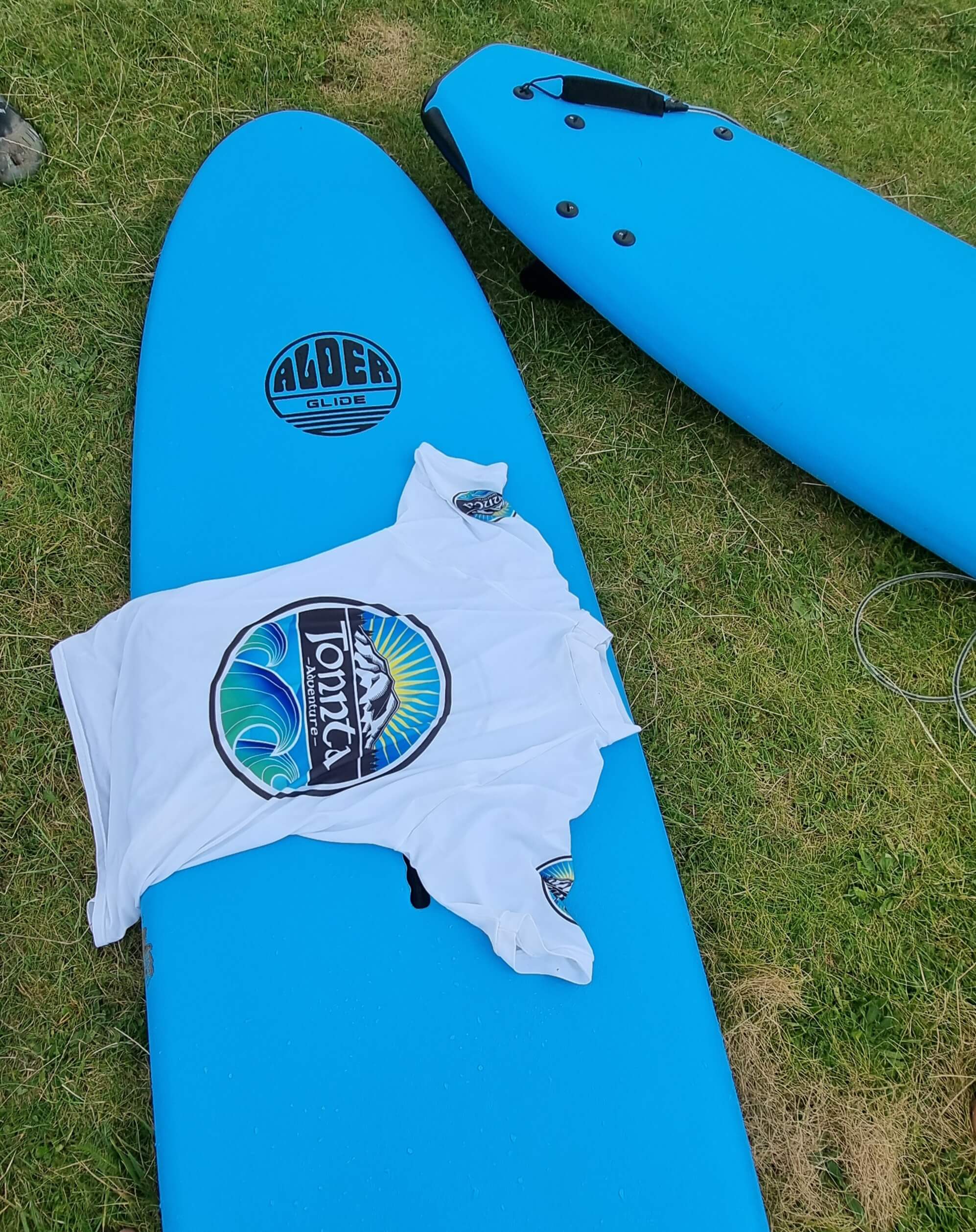 tonnta shirt and blue surf board - surf rentals