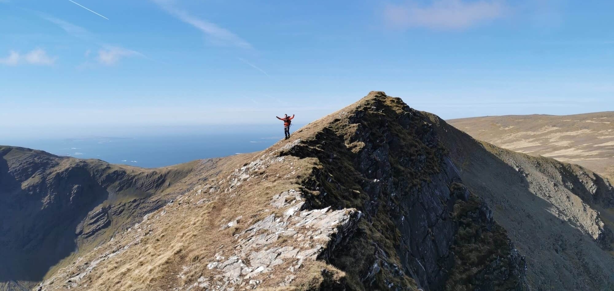 man with open arms in mountain top